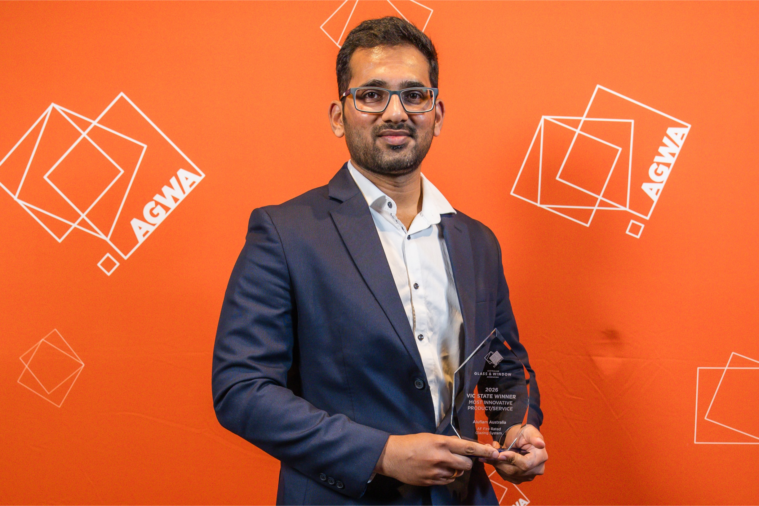 Aluflam Australia representative holding the Most Innovative Product Service Award at the 2026 AGWA Victoria Design Awards